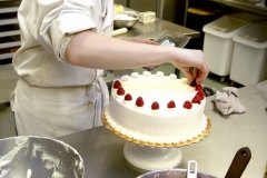 eg 0122 business1 raw ct m5.8 x 9.2Lindsay Heinecke garnishes large rasberries on a  Lemon Rasberry Mousse Torte at Le Cakery, a new buiness opened by Darell and Patti Larson on Watertwon Plank Road.