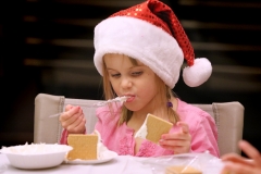 Lauren Gerbitz snacks on icing while making a gingerbread house with graham crackers, cake icing and candies with 60 other people at the Menomonee Falls Library on Dec. 12.