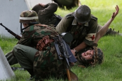 A German medic renders first aid on a wounded soldier as their position is being assaulted by American forces during World War II Days at the Old Falls Village in Menomonee Falls on June 16.