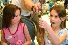 nb 0511 locks1 raw ct m5.8 x 8.4Abby Jaquish is a bit shocked when Karen Whipple hands her the 10-inch hair donation she, Ashley Rusch (left) and seven other mebers of Orchard Lane School's Brownie Troop 482 made to the Locks of Love program.